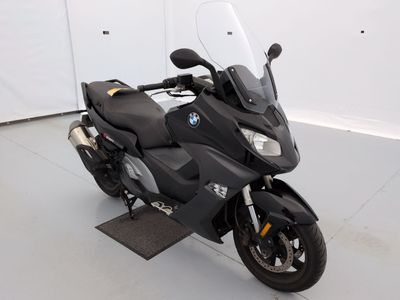 a black motorcycle parked in a room with a white wall