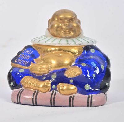 une figurine représentant un homme souriant assis sur une couverture