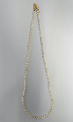 a close up of a white necklace with pearls on a white background