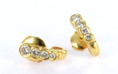 two pairs of gold and diamond earrings on a white surface