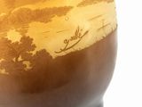 a vase that has a picture of a river in it