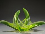 a green glass flower that is sitting on a table