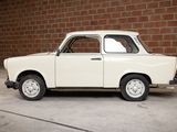 a small white car parked in front of a brick wall