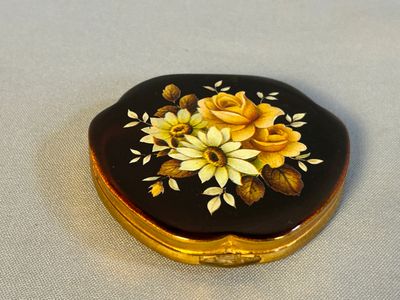 une boîte noire et dorée ornée de fleurs jaunes