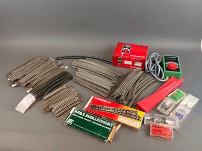 beaucoup de rails et d'autres accessoires de train sur la table