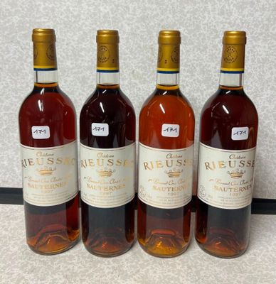quatre bouteilles de vin sont alignées sur un comptoir
