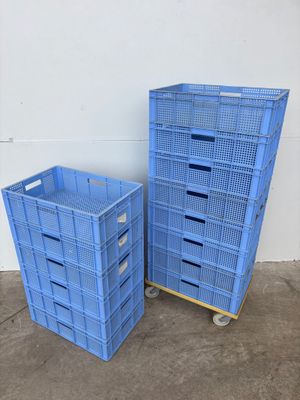 deux caisses en plastique bleues posées l'une à côté de l'autre sur un sol en béton