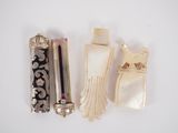 three pieces of ivory and silver jewelry on a white surface