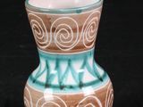 un petit vase posé sur une surface noire