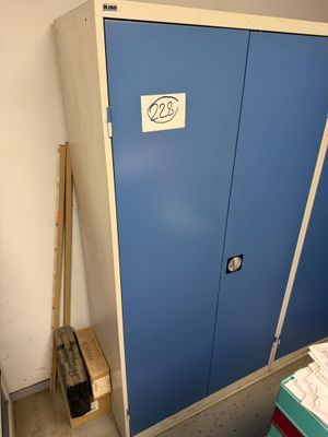 a blue cabinet with a sign on it next to a pile of boxes