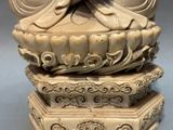 une image représentant une statue d'une femme assise sur un lotus