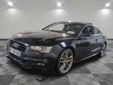 l'audi noire est garée sur le sol en damier d'un garage