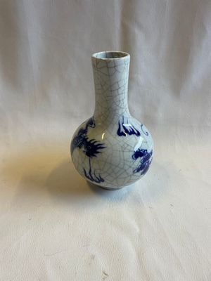 un petit vase bleu et blanc posé sur une table