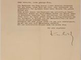 une lettre écrite à l'encre noire sur du papier beige