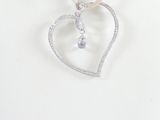 silver heart pendant with a pearl bead hangs on a white mannequin necklace