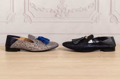 a pair of shoes with tassels on them sitting on a wooden floor