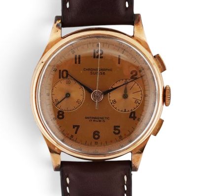a close up of a watch on a white surface