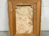 an old picture frame is sitting on the floor in front of a white wall