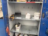 a blue metal cabinet with tools on the shelves