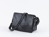 un sac à bandoulière en cuir noir avec des sangles cloutées, sur fond blanc