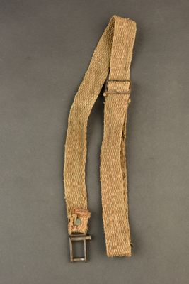 a close up of a belt with a metal buckle on a gray surface