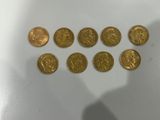 un gros plan d'une personne debout devant une table sur laquelle se trouve un tas de pièces d'or