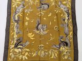 a brown and yellow square scarf with squirrels and flowers on it
