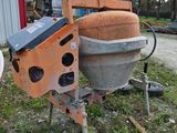 a machine that is sitting in the grass near a building
