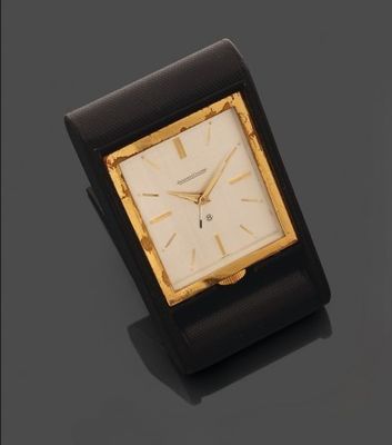 une image représentant une horloge noire et dorée posée sur une surface noire