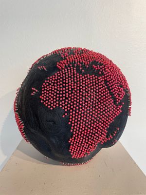 a black ball with red dots on it sitting on a table