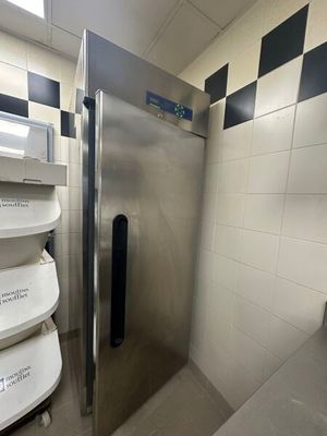une photo d'un réfrigérateur en acier inoxydable dans une salle de bains