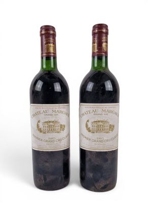 two bottles of wine sitting next to each other on a white surface