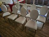 six white chairs sitting in a row on a wooden floor