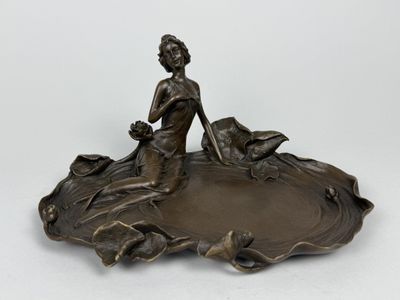 une image d'une statue en bronze représentant une femme tenant un oiseau