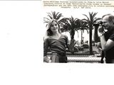 black and white photograph of a man and a woman in front of a palm tree