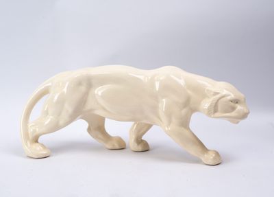 une figurine représentant un chat marchant sur une surface blanche