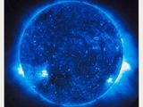 an image of a large blue sun in the dark sky