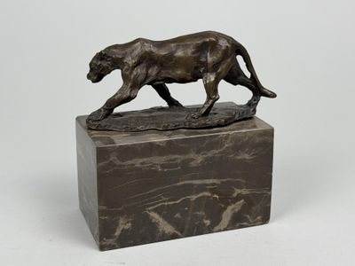 sculpture en bronze représentant un lion sur un socle en marbre