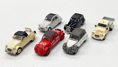 plusieurs petites voitures sont alignées sur une surface blanche