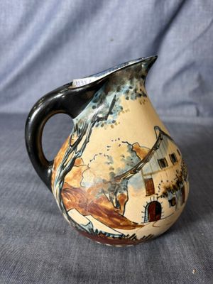 un petit vase avec un tableau posé sur une table