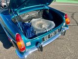 a blue car with its trunk open on the street