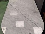 a marble table in the middle of a room with chairs