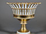an image of a gold and white striped bowl on a stand