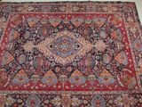 un tapis oriental posé sur un sol blanc, orné d'un motif rouge et bleu