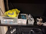 a black shelf with a bunch of wires and other items on it