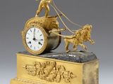 une horloge en or représentant un homme dans une calèche