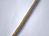 a close up of a gold chain bracelet on a white surface