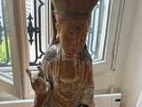 a statue of a person sitting on a stool