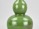a green vase with a double gourd design on it