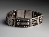 a close up of a silver bracelet on a white surface
